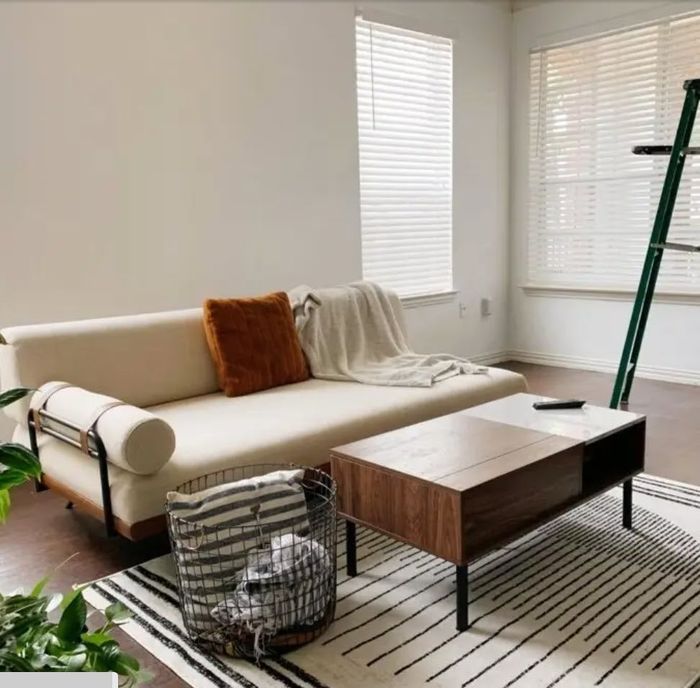 A small, white, modern futon-style flat couch