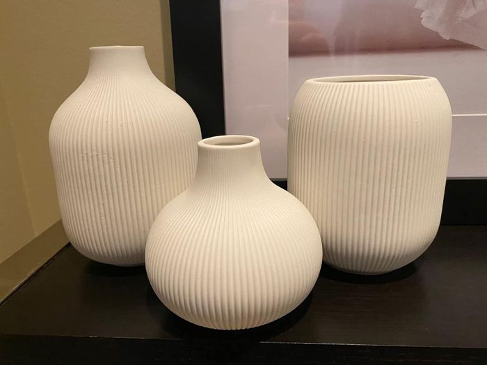reviewer's three uniquely shaped cream-colored vases