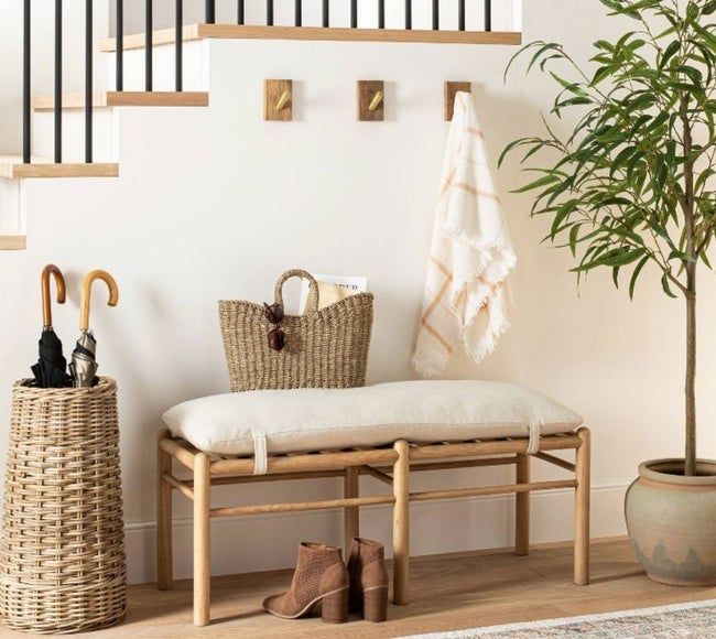 A wood-framed accent bench with cream upholstery