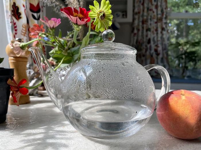 A reviewer's image of the glass teapot filled with steaming hot water, highlighting its elegant simplicity.