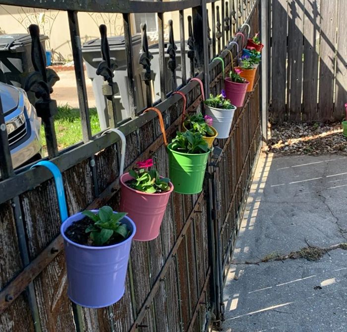 A photo shared by a reviewer showing the flower pots hanging neatly from a fence.