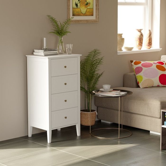 Stylish four-drawer white dresser placed in a cozy bedroom setting