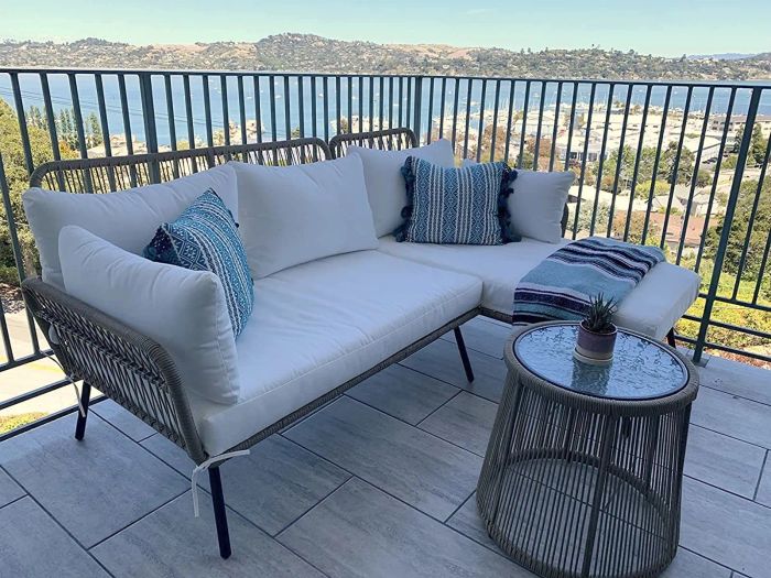 A sectional sofa with a chaise and a small table displayed on a balcony, perfect for outdoor lounging.