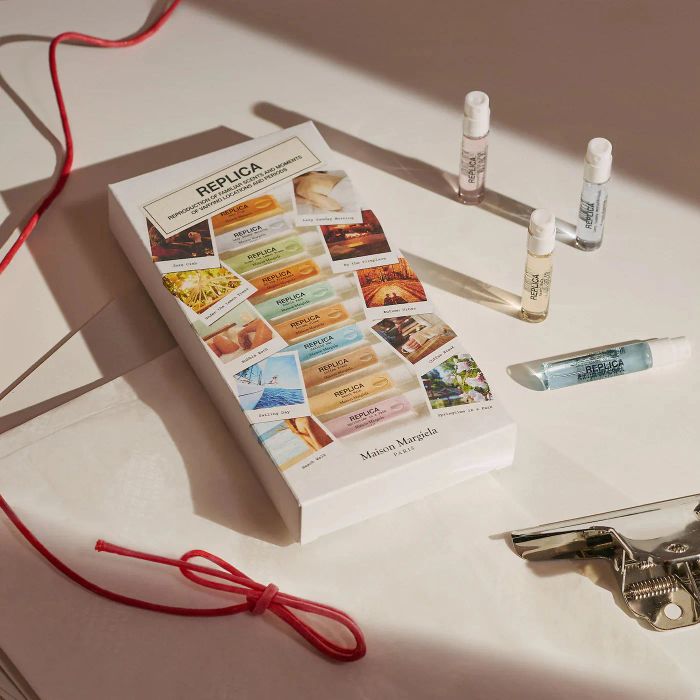 A gift box with scattered perfume bottles around it.