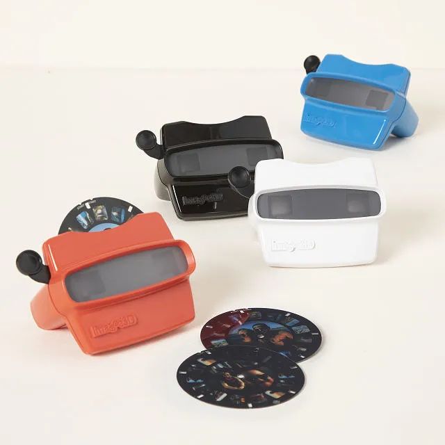 A set of four reel viewers in red, black, white, and blue.