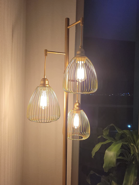 closeup of reviewer's lamp with three Edison bulbs encased in wire shades, standing independently