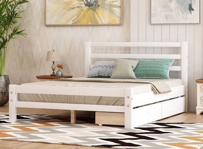 A sleek modern bedroom featuring a white bedframe with convenient under-bed storage drawers, complemented by a bedside table with a lamp, and two large paintings hanging above the bed.
