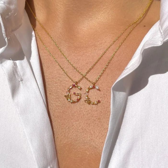 Model showcasing two necklaces with the initials "G" and "C"