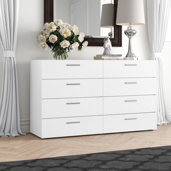 A white eight-drawer dresser with silver handles
