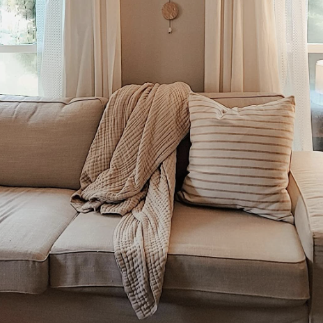 Blanket draped over a gray sofa