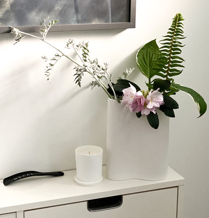 Reviewer showing the white infinity vase filled with flowers