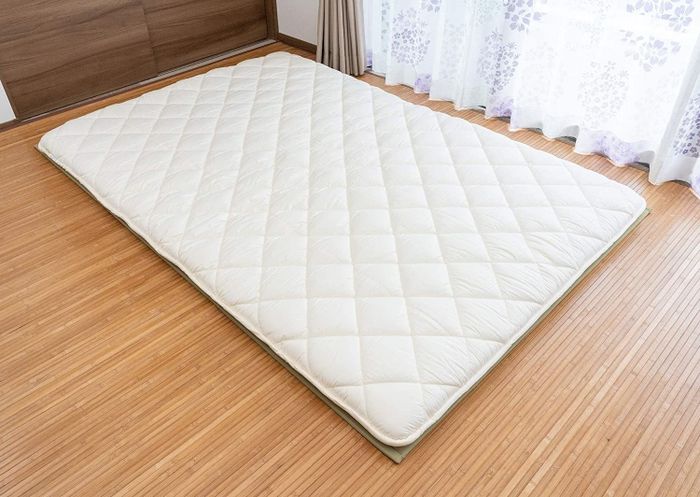 The white futon laid flat on the floor