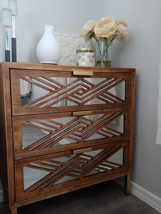Reviewer's photo of a small mirrored dresser with vases on top
