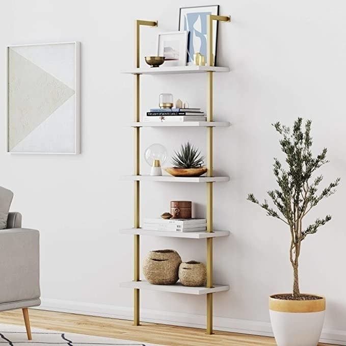 the gold and white shelf showcasing books and decorative items