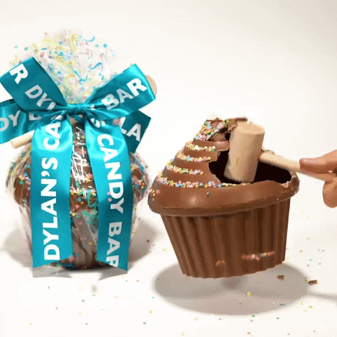 Gif of a hand smashing a chocolate  cake to reveal chocolate-covered pretzels hidden inside