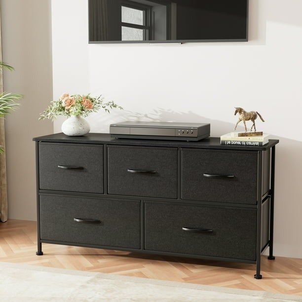 A five-drawer fabric dresser styled with decorative accents on top