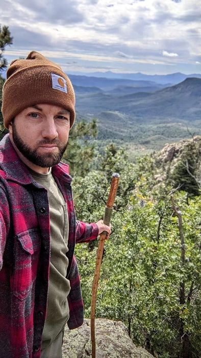 A photo of a reviewer wearing a Carhartt beanie while hiking.