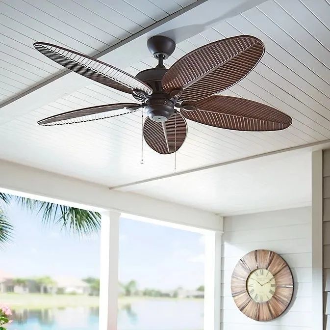 The brown fan hanging from a porch ceiling, adding style and comfort.