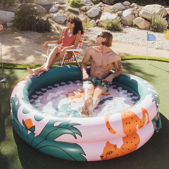 Two people enjoying a swim in a brightly colored inflatable pool.