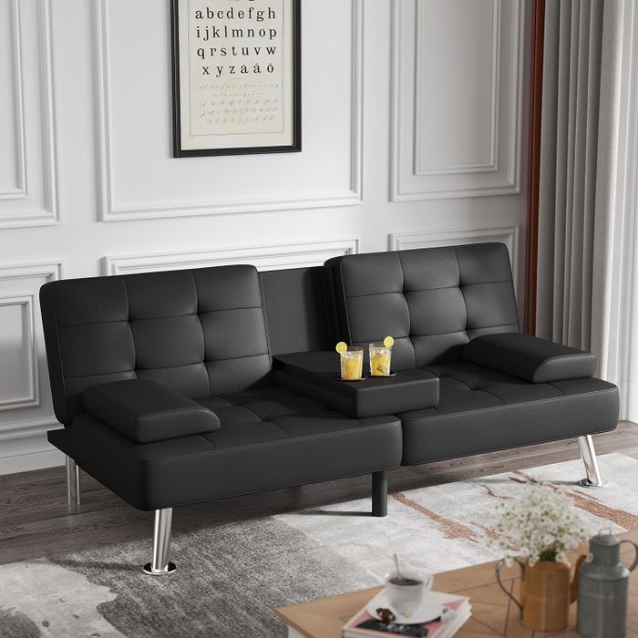 the black faux leather futon sofa upright with cupholders holding drinks