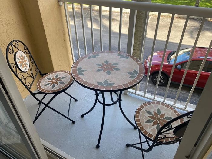 A bistro set is displayed on a quaint, small patio space.