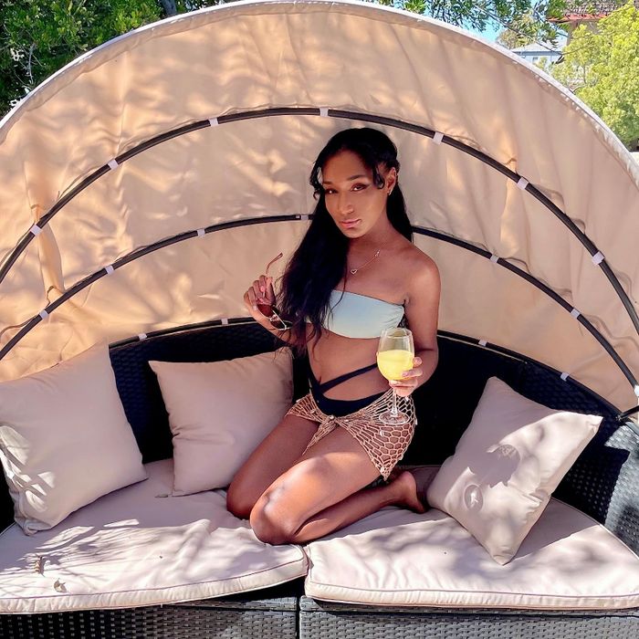 a reviewer relaxing on the daybed with a drink in hand