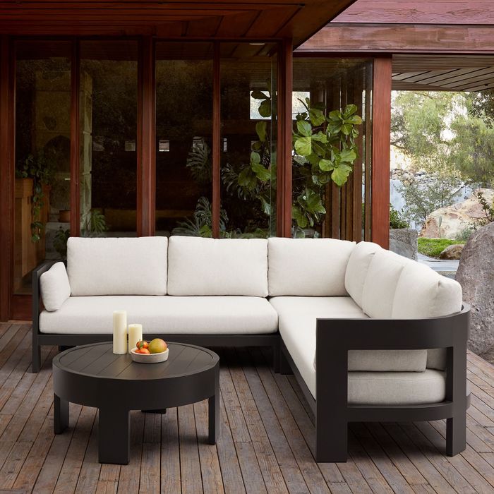 An outdoor furniture set featuring a sectional sofa and a table, perfectly arranged on a patio.
