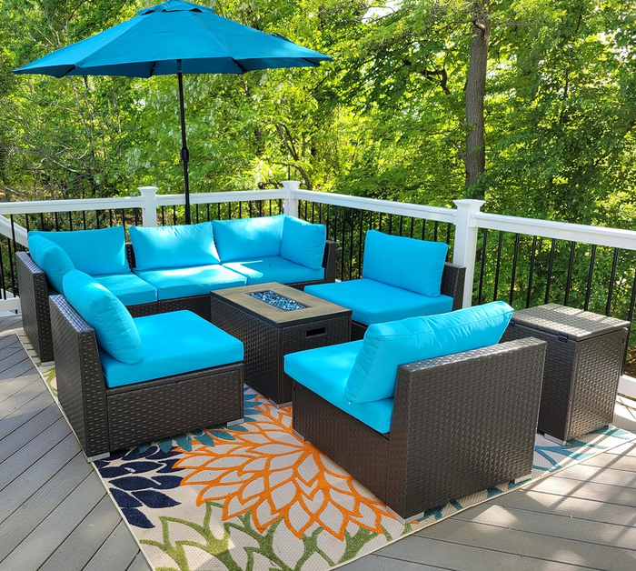a reviewer's outdoor patio set featuring a turquoise sectional and fire pit on a deck