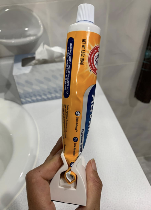reviewer holding the toothpaste securely in its holder