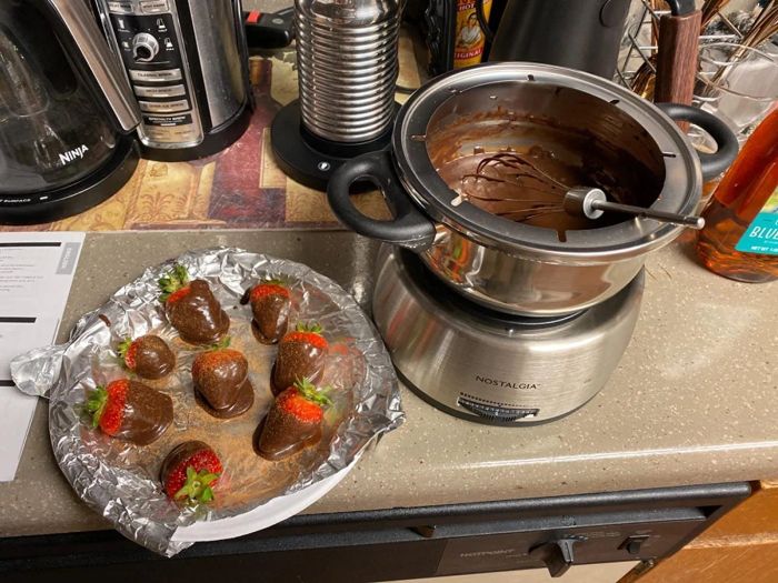 The fondue pot in action, with a plate of delicious chocolate-dipped strawberries nearby.