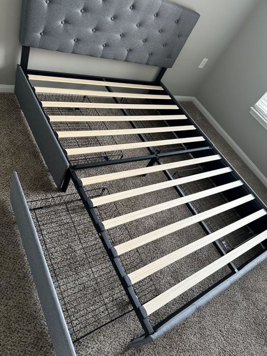 A newly assembled bed frame combining wooden slats and black metal wires, showcased in a bedroom setting.
