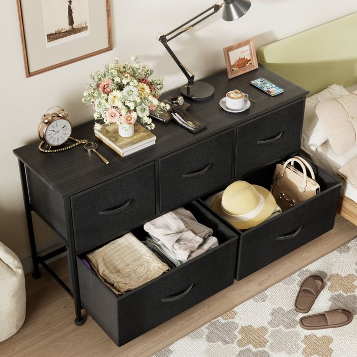 Bird’s-eye view of the dresser with drawers open, revealing neatly arranged clothes and accessories inside