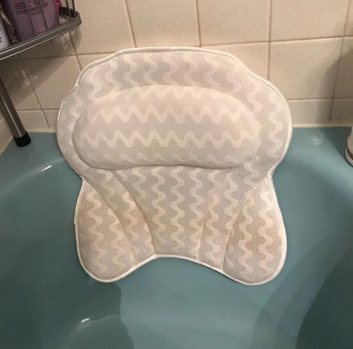 The bath pillow firmly attached to a blue bathtub.