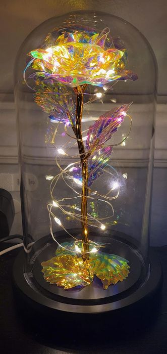 Reviewer photo of the artificial rose glowing inside its glass dome