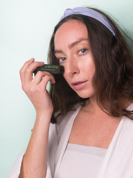 A model applying the matcha stick to their face