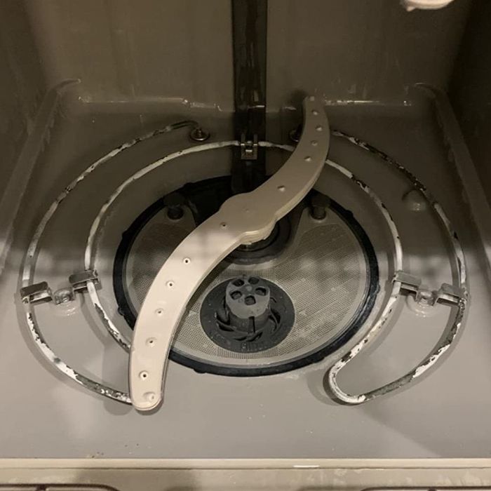 The same reviewer showing their dishwasher looking spotless and brand new after using the cleaning tablets.