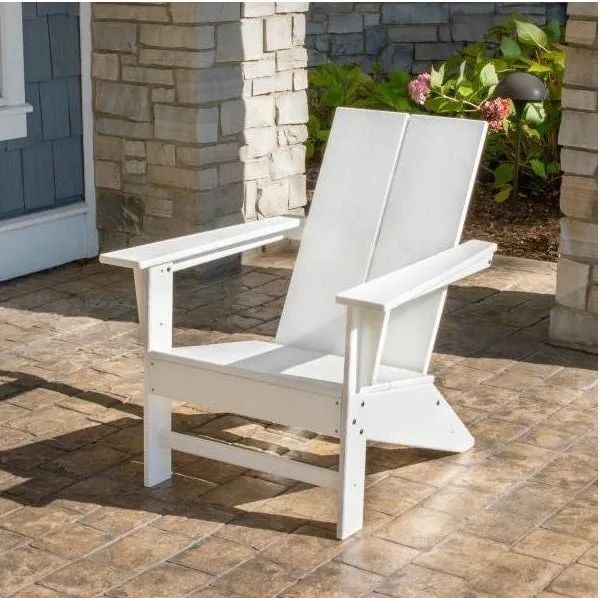 A white Adirondack chair placed outside a house, adding charm to the outdoor space.