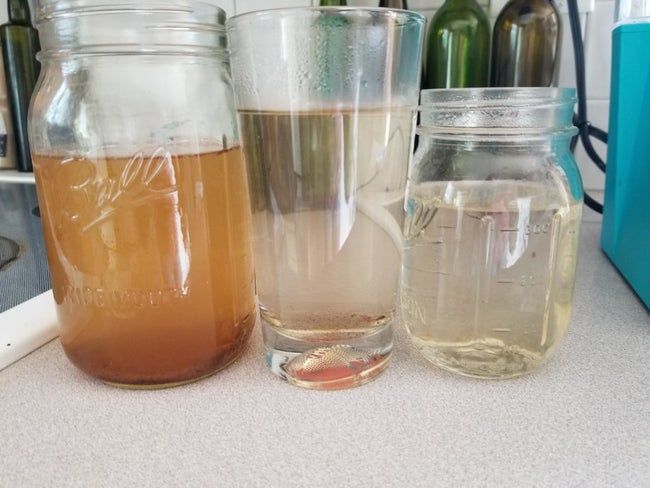 A reviewer’s photo of the water that came out of their Keurig after using the K-Cup cleaning pod, showing the brown water gradually becoming clearer after each cycle
