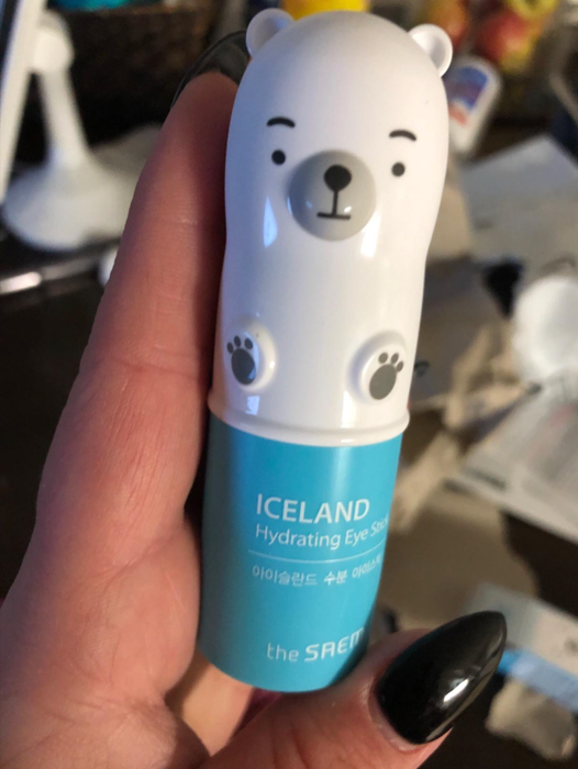 A reviewer holding the small polar bear-shaped eye stick in their hands