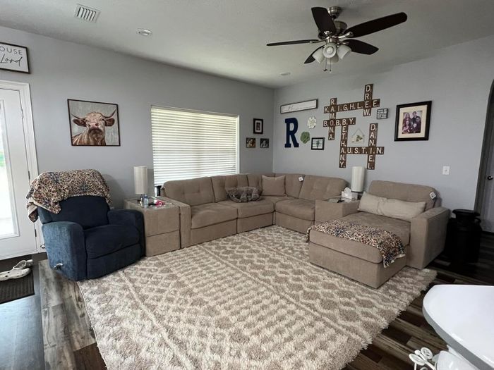 A reviewer image showcasing the beige area rug in a living room.