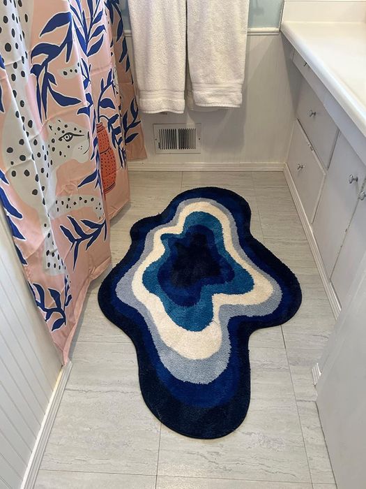 Reviewer image of the blue cloud-shaped rug in a bathroom.