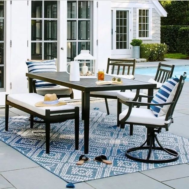 The bench paired with a matching table and chairs, creating a complete outdoor seating arrangement.