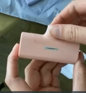 A gif of a reviewer holding the pink charger and demonstrating its built-in lightning cable