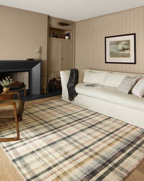 A plaid rug adds texture and color to a living room, bringing a cozy, seasonal feel to the space.