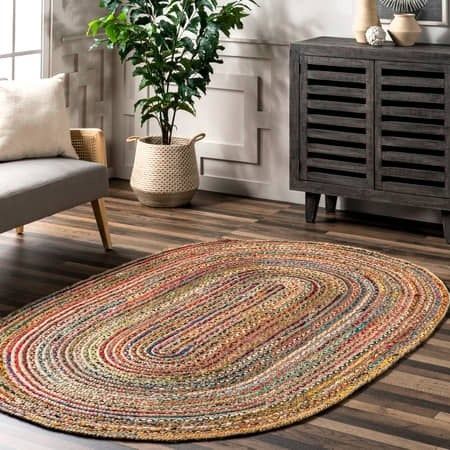 The oval-shaped, multi-colored jute rug placed elegantly in a living room.