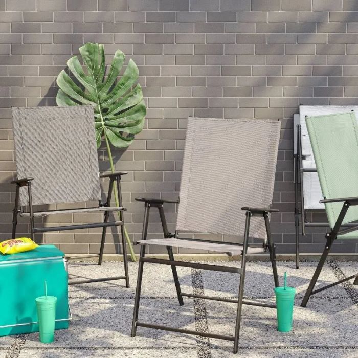 The gray and tan folding chairs placed on a patio.
