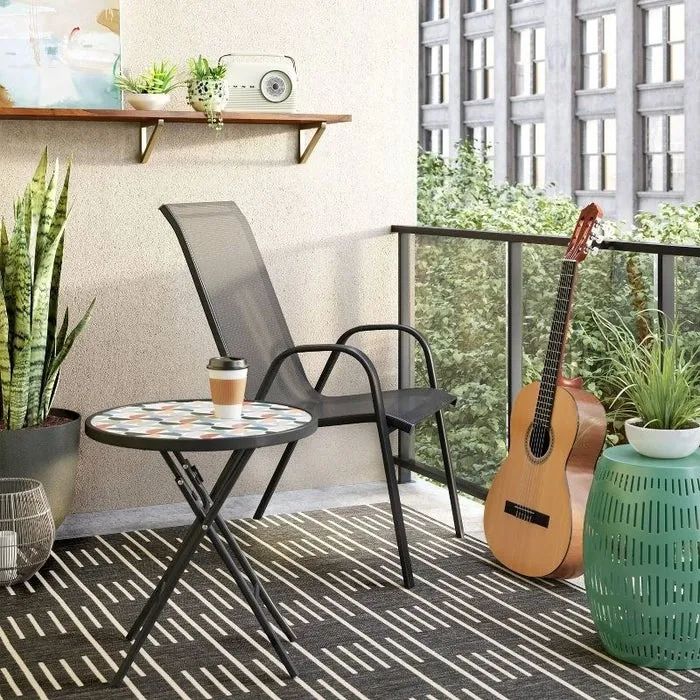 The black chair perched on an apartment balcony.