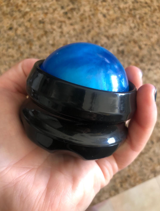 Reviewer holding a blue stress ball with a black gripper.