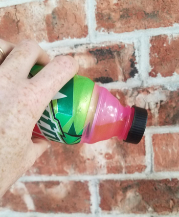 A reviewer tilting the can to demonstrate the leak-proof seal in action.