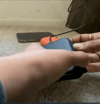 A reviewer demonstrating how the black charger unfolds from its compact form into the three-section mat